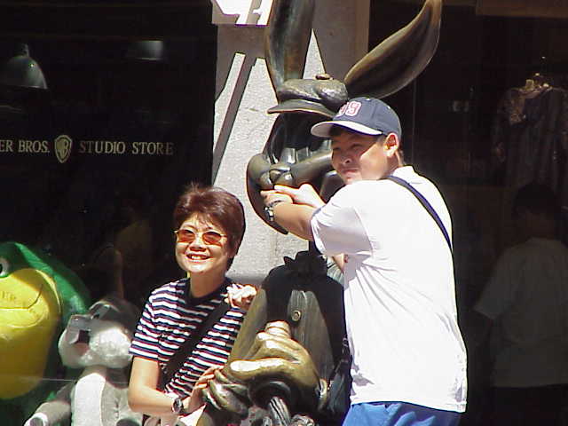 A mother and son pose for a photo with a statue of Bugs Bunny at Quincy Market in Boston