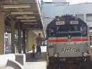 A dad helps his son peer into the cab of an Amtrak engine