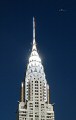 a helicopter near the top of the Chrysler Building